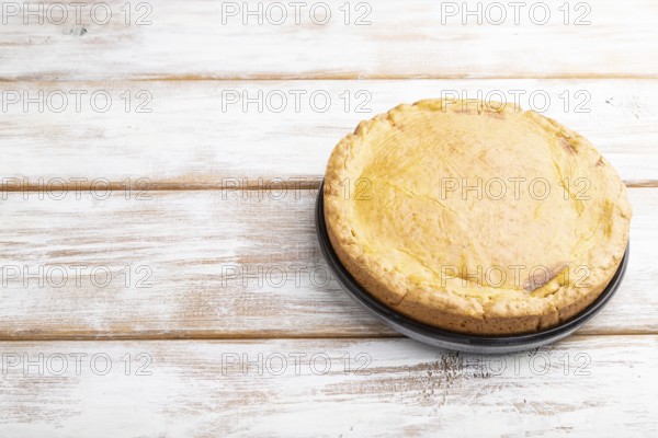 Autumn onion pie and cup of coffee on white wooden background. Side view, copy space, close up