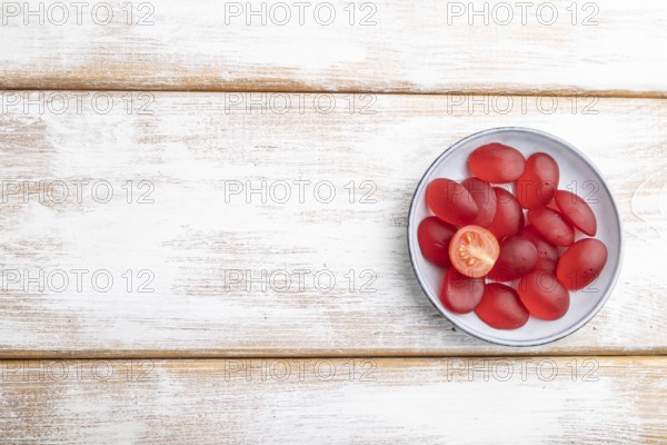Jelly tomato candies on white wooden background. copy space, top view, flat lay