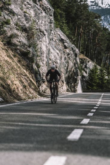 Road bike rider in spring in the Allgäu against the picturesque backdrop of the Alps, Bavaria,
