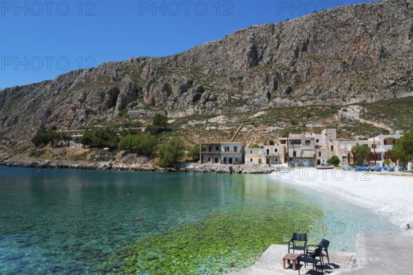 Secluded bay with crystal clear water and houses under steep mountains, Geromilenas, Mani, Laconia,