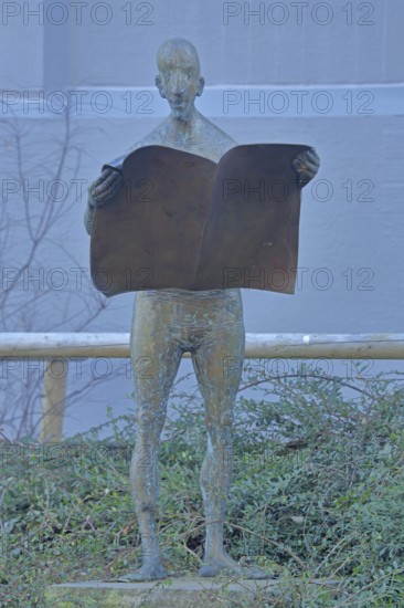 Sculpture Newspaper Reader by Karl Ulrich Nuss 2005, bronze sculpture, male figure reading a