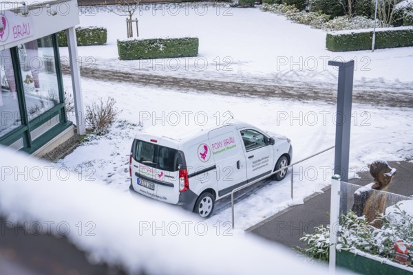 Snow-covered car park with delivery van at a shop, wintry atmosphere, spa garden, Bad Wildbad,