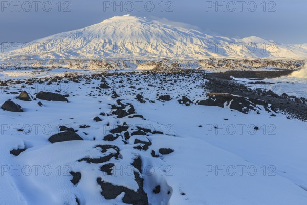 Rocks, lava field and surf at the coast, evening light, sun, snow, winter, Arnarstapi,