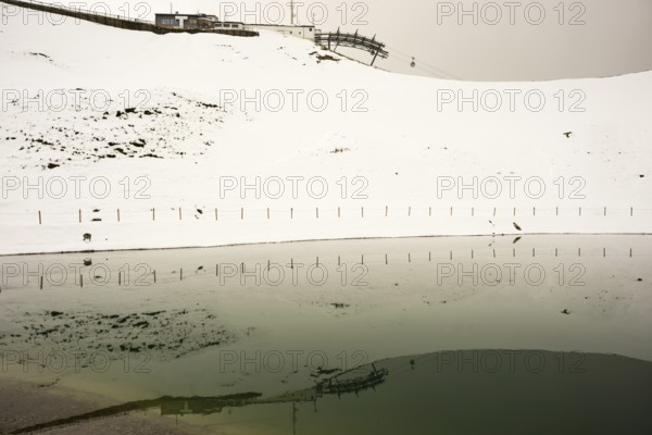 Onset of winter in May, Riezler Alpsee, an artificial lake, snow pond, feeds the snow cannons that
