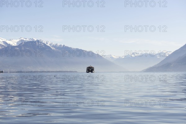 Passenger Ship on an Alpine Lake Maggiore with Snow Capped Mountain in a Sunny Day in Locarno,