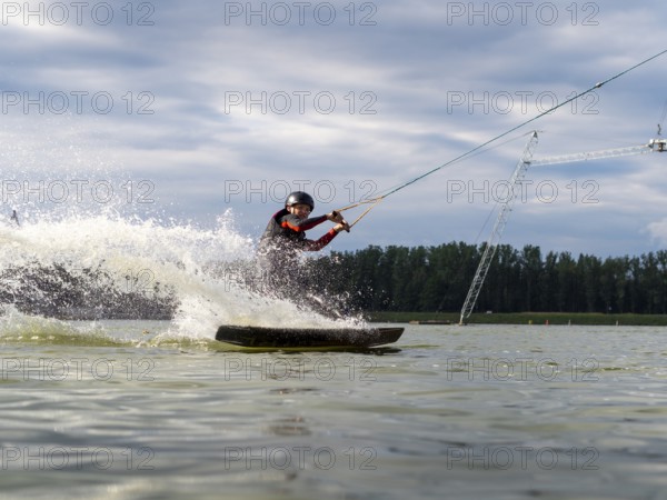 Man rides fast with wakeboard, water sports, water skiing and wakepark, Stráž pod Ralskem, Czech