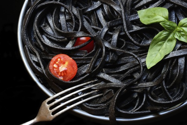 Black pasta coloured with squid ink on a plate, Taglioni al Nero di Seppia, Italy, Europe