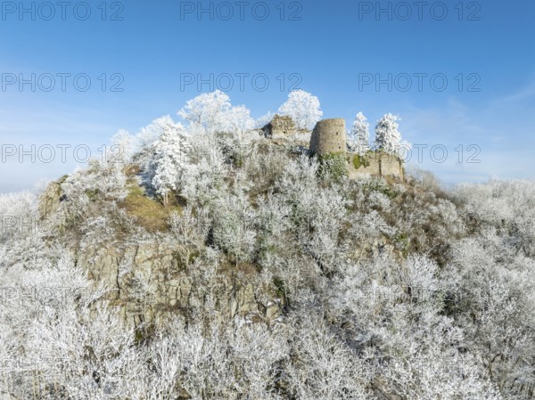 Aerial view of the snow-covered Hegau volcano Mägdeberg, with remains of a castle wall, surrounded