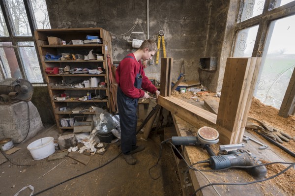 Young man builds a table in his workshop, Mecklenburg-Vorpommern, Germany, Europe