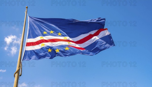 The flag of Cape Verde flutters in the wind, isolated against a blue sky