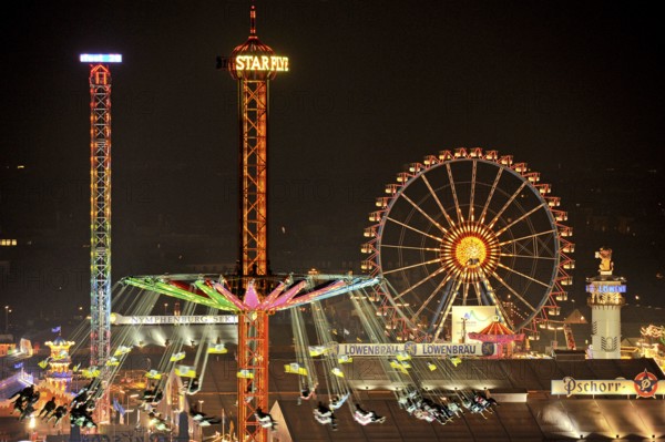View over the Wies'n at night with illuminated carousel, Ferris wheel, stalls, beer tents and