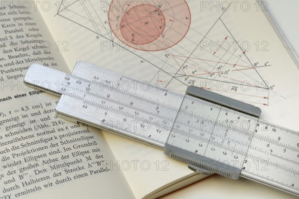 Slide rule on book, calculating aid