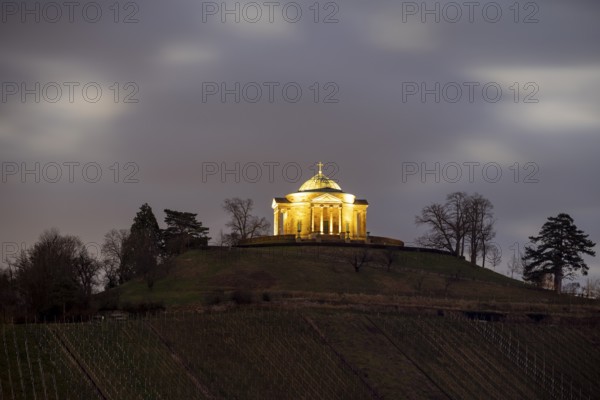 Burial chapel on the Württemberg on a hill at night with cloudy sky and trees in the background,