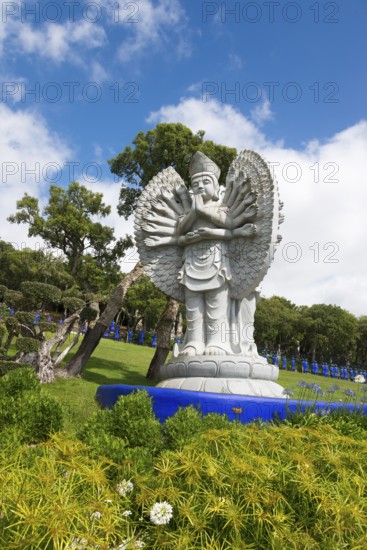 Statues of Buddha in a manicured garden with trees and a blue sky, Bacalhôa, Bacalhoa Buddha Eden,