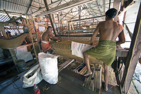 Indian workers in the weaving mill of the Labourers Coir Mats and Mattings Cooperation, coir mat