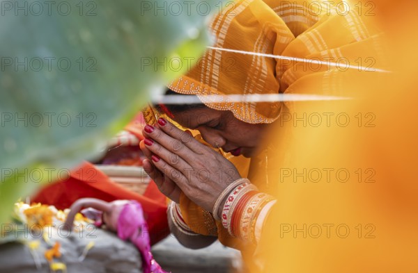 Hindu devotees perform rituals as they offer prayers to the Sun god in the bank of Brahmaputra