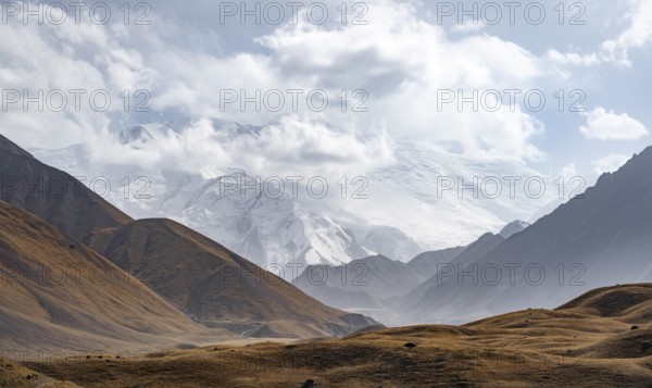 Dramatic mountain landscape, mountain valley, behind glaciated and snow-covered mountain peak Pik