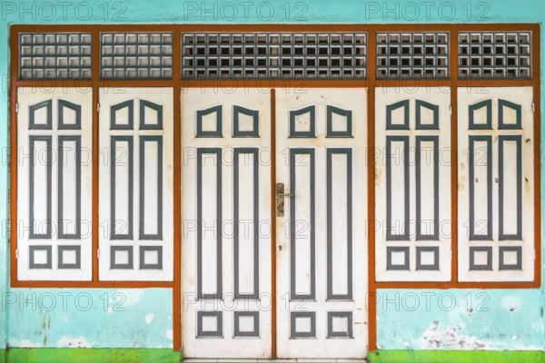 Closed, dilapidated building with peeled off house wall in turquoise colour, pastel, green,