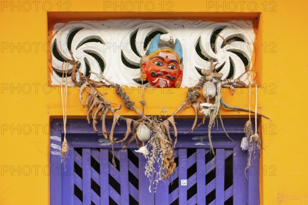 Purple-coloured front door, yellow wall, house entrance with demon mask, Rameswaram or Rameshwaram,