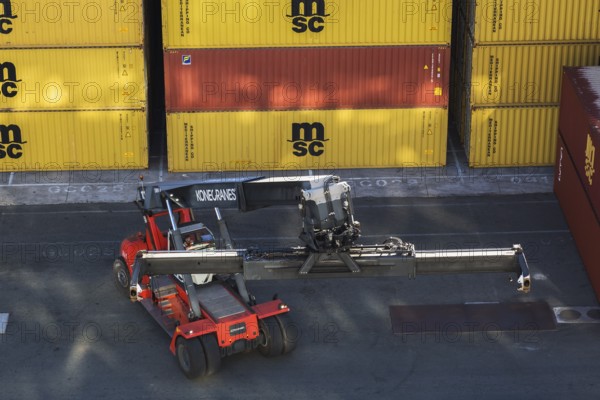 Stacked MSC, FLORENS metal box shipping containers and Kone Cranes container handler on dock in La