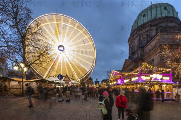 Ferris wheel at the winter village, Christmas market at dusk, St Elisabeth's Church on the right,