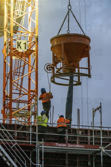 Concrete work, at dusk, on a large construction site building a residential and commercial complex,