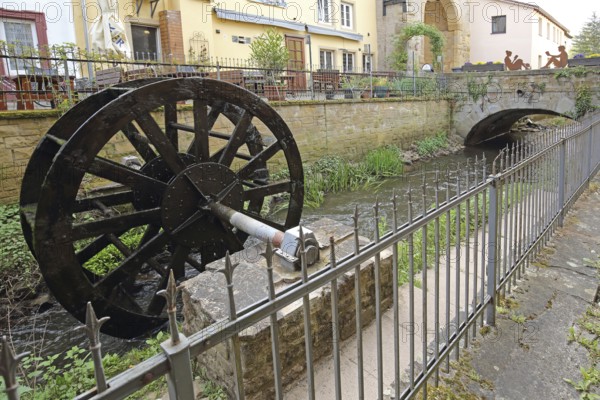 Waterwheel at the stream casting with metal fence, idyll, Meisenheim, Rhineland-Palatinate,