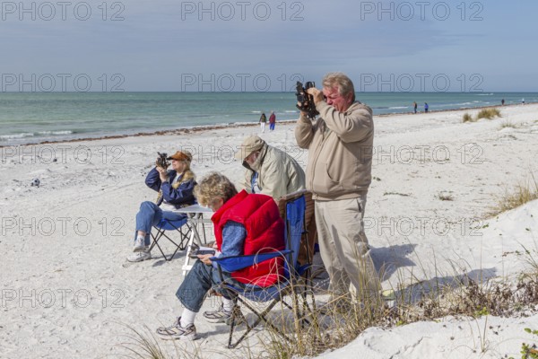 Men and women using sextants on the white sand beach of Indian Shores, Florida, USA, North America