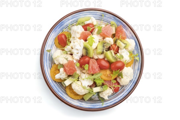 Vegetarian salad of cauliflower cabbage, kiwi, tomatoes, microgreen sprouts isolated on white