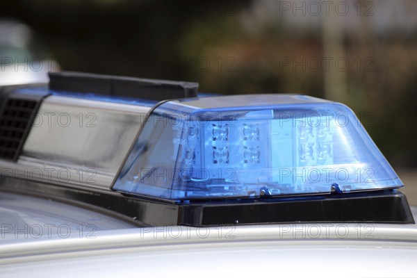 Symbolic image: Close-up of a police car with flashing blue lights