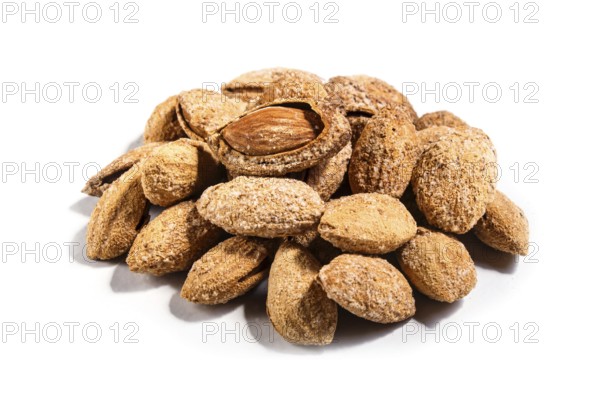 Pile of sweet almond nut with shell and salt isolated on white background. Closeup