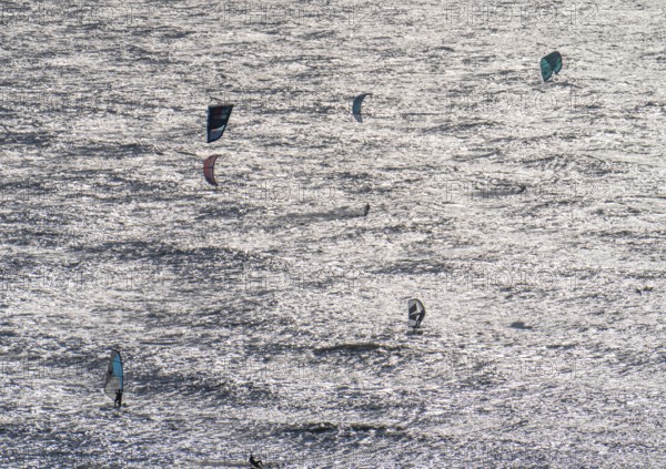 Kitesurfers and windsurfers in strong winds on the beach of Scheveningen, The Hague, Netherlands