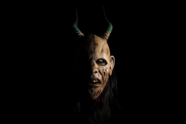 Devilish mask with horns and a terrifying expression in a gloomy atmosphere