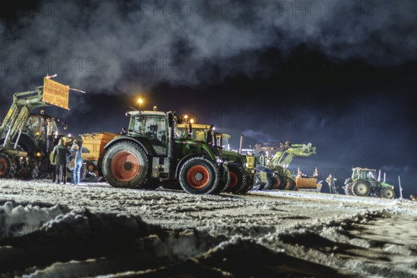 Tractors during a rally as part of the farmers' protests on the snow-covered Kirchbichl,