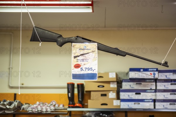 Hunting rifle hanging in supermarket with price tag, Inuit settlement Ittoqqortoormiit,