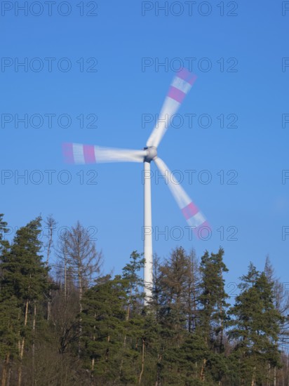 Wind Turbine, on a ridge in a forest, taken with a long exposure to create an abstract blurred