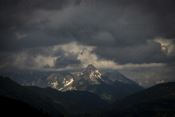Summit of the Biberkopf with remnants of snow and dramatic clouds, Lech, Lechquellengebirge,