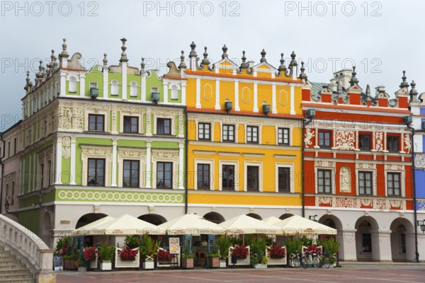 Historic Renaissance houses with colourful facades in a lively market scene, Great Market, Zamosc,