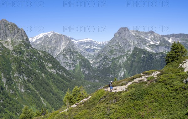 Mountaineer on hiking trail to Aiguillette des Posettes, mountain panorama with summit Mont Bues