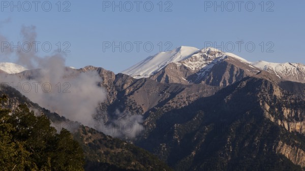 Mountains with snow-covered peaks and some clouds in a calm, natural atmosphere, Omalos Plateau,