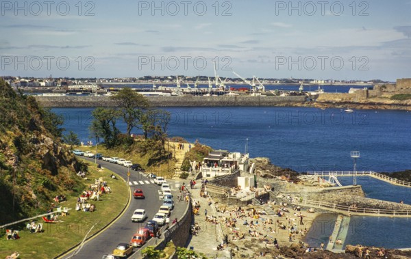 Menschen beim Sonnenbaden an der Küste, St. Peter Port, Guernsey, Kanalinseln, Großbritannien, Juni