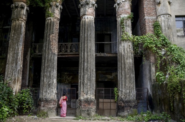 Woman standing below old palace, Kolkata, West Bengal, India, Asia