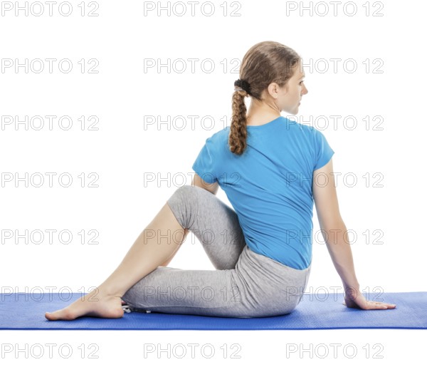 Yoga, young beautiful slender woman yoga instructor doing Half Lord of the Fishes Pose (Half Spinal