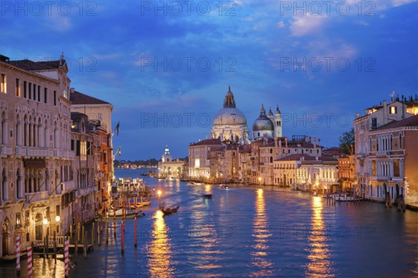 View of Venice Grand Canal with boats and Santa Maria della Salute church in the evening from Ponte