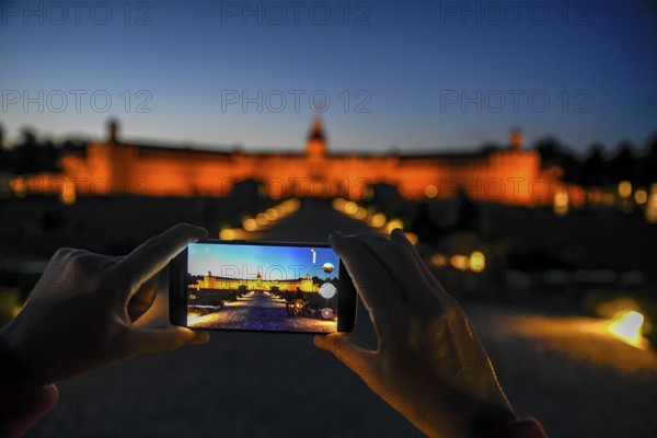Karlsruhe castle at dusk in the display of a mobile phone, Karlsruhe, Baden-Württemberg, Germany,