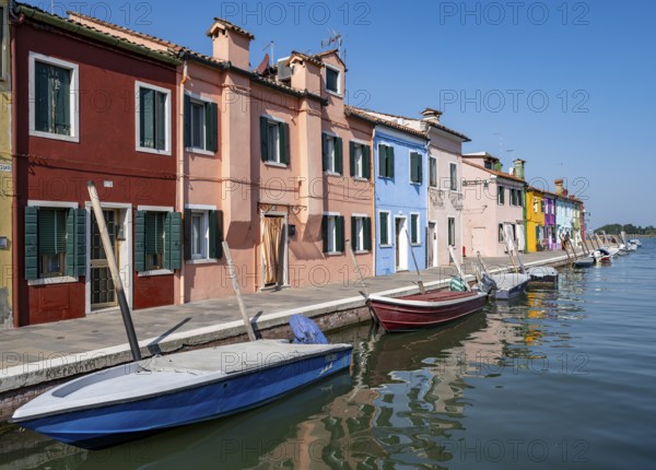 Colourful houses on the canal, canal with boats and colourful house facades, Burano Island, Venice,