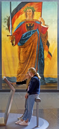 Two woman at a screen in front of the painting of Germania by Philipp Veit, Haus der Geschichte,