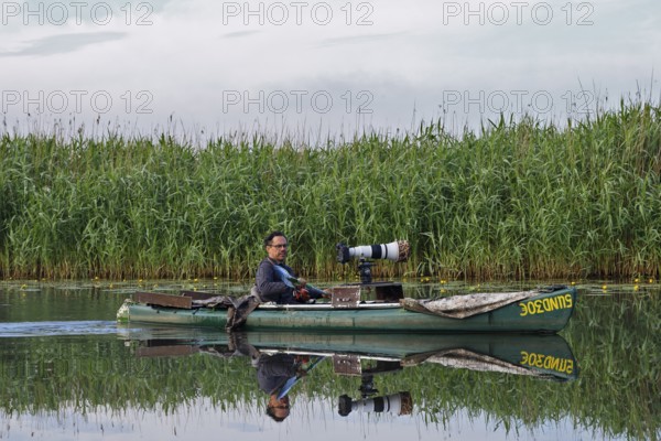 Nature park photographer in a kayak on the river Trebel at work, Naturpark Flusslandschaft
