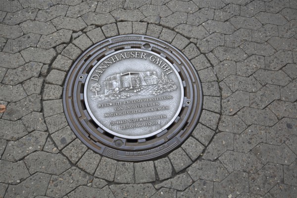 Manhole cover as advertising from the company Dannhäuser GmbH for individual production of motifs,