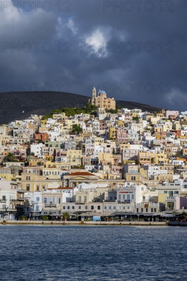 View of the town of Ermoupoli with pastel-coloured houses and the sea, on the hill Anastasi Church